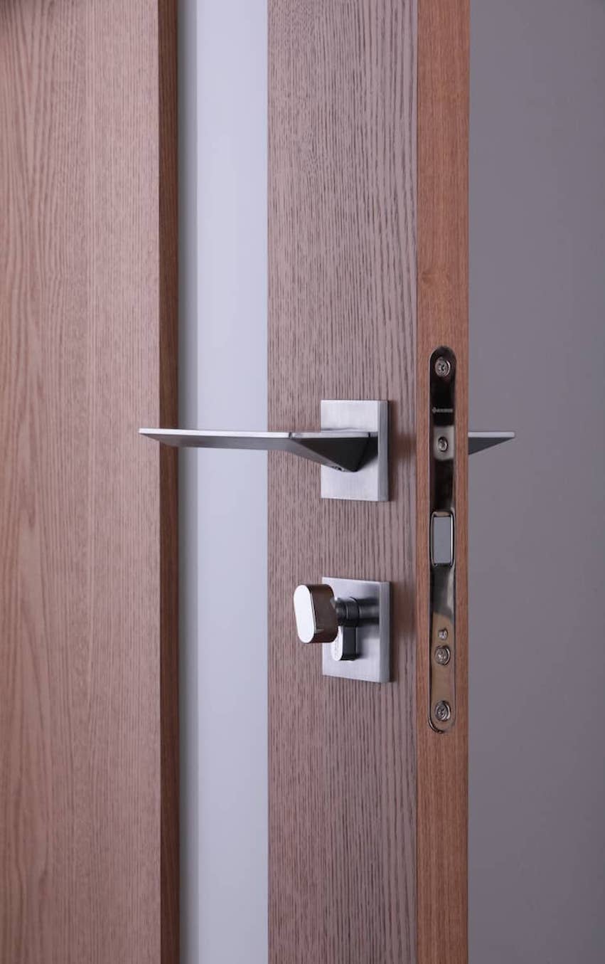 maniglia in acciaio su porta color legno scuro